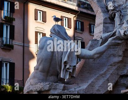 Rome, Italie - 16 juin 2026 : Statue du Dieu du Nil depuis la fontaine des quatre fleuves avec une mouette sur sa tête, présentant des détails de pierre complexes Banque D'Images