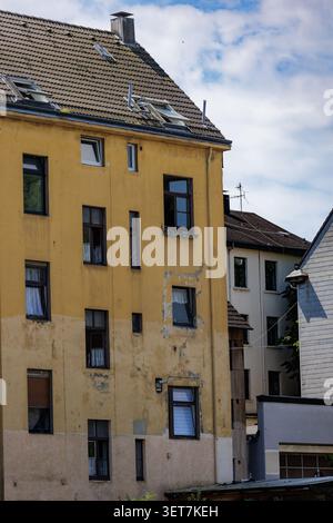 Façade jaune vieillie de bâtiment d'appartement avec murs et fenêtres altérés Banque D'Images