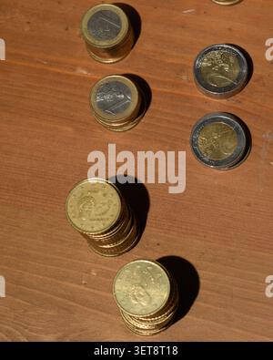 Vue de dessus des piles de pièces triées de 1 et 2 euros sur une surface en bois, illustrant l'organisation des caisses, le comptage des caisses, la gestion des paiements et la petite usine Banque D'Images