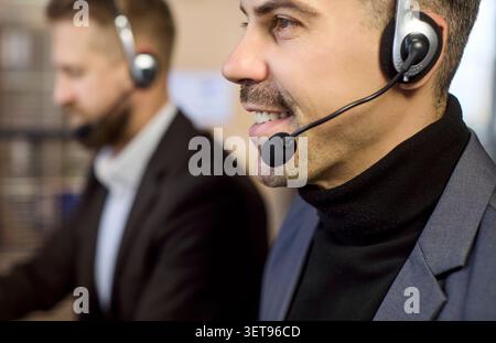 Gros plan sur un agent d'assistance du centre d'appels portant un micro-casque au bureau Banque D'Images