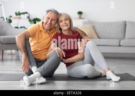 Heureux couple âgé caucasien pratiquant le yoga à la maison, un style de vie sain et le concept de bien-être Banque D'Images