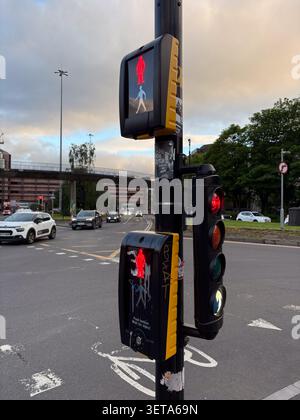 Signal de passage pour piétons avec feu stop rouge à Glasgow, en Écosse, montrant la circulation routière et les infrastructures urbaines. Banque D'Images
