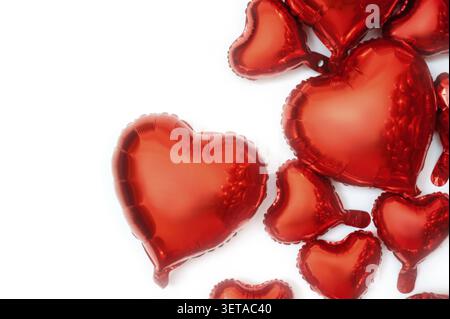 Fond blanc pour le texte et les ballons de feuille en forme de coeurs. Ballons de différentes tailles de grands à petits coeurs. Les cœurs de ballon sont situés o Banque D'Images
