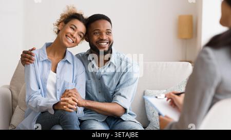 African American Couple Hugging positive après la conciliation au Bureau du psychologue Banque D'Images