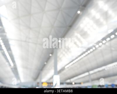 Intérieur du terminal aéroportuaire floue avec plafond architectural moderne et lumières défocalisées, représentant les voyages, les transports, les voyages d'affaires, les touri Banque D'Images