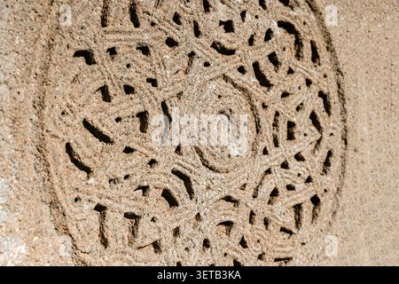 Gros plan détaillé d'une ancienne sculpture en pierre chrétienne géorgienne ornée d'ornements géométriques et floraux circulaires complexes. Photo de haute qualité Banque D'Images