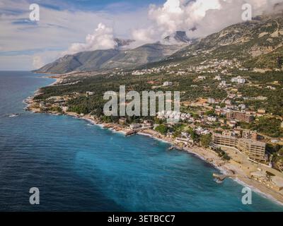 Une perspective aérienne capture la magnifique côte albanaise de la Riviera, mettant en valeur les eaux turquoises vibrantes de la mer Ionienne, qui rencontrent sable et ro Banque D'Images