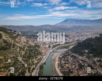 Une vue aérienne panoramique capture la ville historique de Berat, en Albanie, avec la rivière Osum serpentant en son centre. Le pont Gorica relie le Banque D'Images