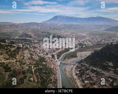 Une vue panoramique aérienne capture la ville historique de Berat en Albanie, mettant en valeur ses maisons ottomanes blanches traditionnelles descendant les collines, bis Banque D'Images