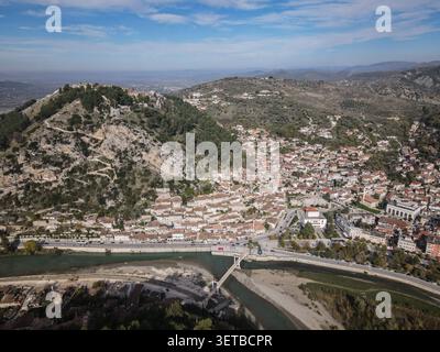 Une vue aérienne large capture la ville historique de Berat, en Albanie, avec ses maisons de l'époque ottomane qui grimpent sur la colline. La rivière Osum coule Banque D'Images