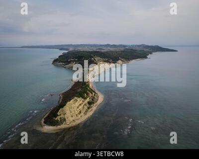 Une vue aérienne capture la côte accidentée et distinctive du cap Drastis à Corfou, en Grèce, qui s'étend dans la mer Ionienne sous un ciel couvert. Le i Banque D'Images