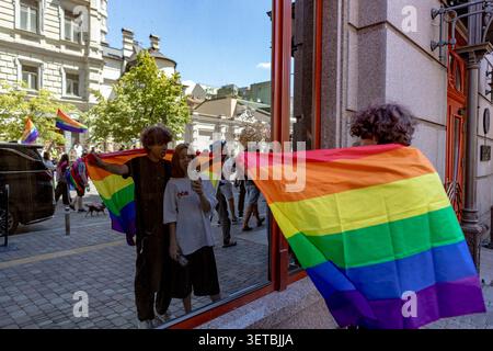 Kiev, Ukraine. 21 juin 2026. Deux participants se drapent dans un drapeau arc-en-ciel en posant à côté d'une fenêtre réfléchissante après Kyiv Pride à Kiev, Ukraine, le dimanche 21 juin 2026. L'événement annuel s'est tenu dans des conditions de sécurité renforcées pendant la guerre qui a suivi l'invasion à grande échelle de la Russie en février 2022. (Photo : Vudi Xhymshiti, pour The Pictures UK) crédit : VX Pictures/Alamy Live News Banque D'Images