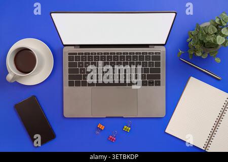 Maquette d'ordinateur portable avec écran blanc sur fond bleu pour le concept de travail à distance Banque D'Images
