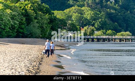 Couple senior marchant pieds nus le long de la plage de la mer Baltique le jour d'été ensoleillé Banque D'Images
