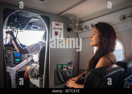 Passager assis derrière le poste de pilotage sur le vol d'hydravion transmaldivien Banque D'Images