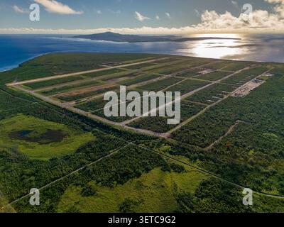 Vue aérienne de North Field base avec des pistes historiques entourées d'une végétation tropicale dense et de l'océan Pacifique dans le nord de Tinian, Tinian, Northe Banque D'Images