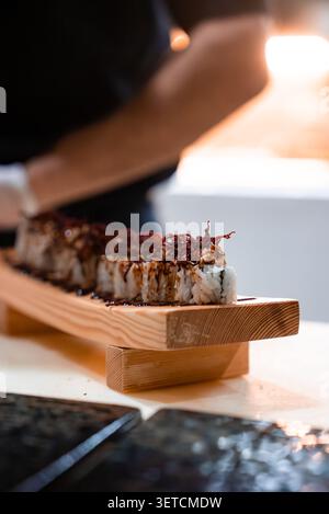 Petits pains de sushi gourmands sur planche geta en bois dans la station balnéaire des Maldives Banque D'Images