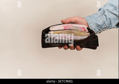 Pile de billets visiblement entassés dans un portefeuille ouvert. Cette réserve de trésorerie illustre la préparation, la prospérité ou la méthode de paiement direct. Ukrainien h Banque D'Images