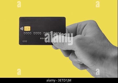 Collage créatif en demi-teintes avec une main tenant une carte de crédit. Concept moderne de paiement en ligne et d'achat numérique représentant le e-commerce, sans espèces Banque D'Images