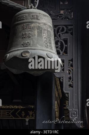 Chongqing, Chine - 11 juin 2026 - la cloche en bronze altérée est suspendue avec une dignité ancienne et calme à l'intérieur du temple Luohan, dont la surface est gravée de tradi Banque D'Images