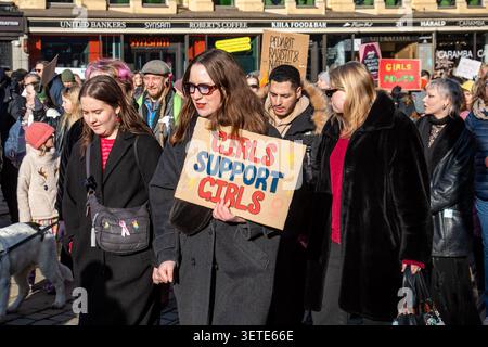Girls soutien Girls. Participante tenant une pancarte faite à la main lors de la marche de protestation de la Journée internationale de la femme sur Aleksanterinkatu à Helsinki, Finlande. Banque D'Images
