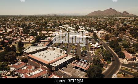 Vue aérienne d'un centre commercial de banlieue avec un club de fitness, un parking, et le quartier résidentiel environnant avec des montagnes désertiques à Phoenix, Banque D'Images