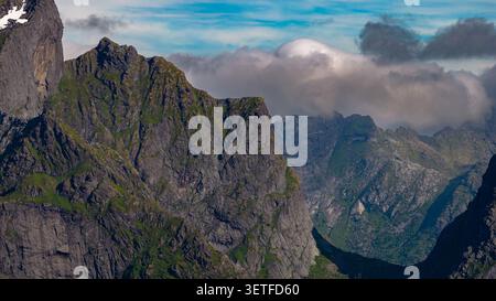 Majestueuse vallée alpine des Lofoten, en Norvège, avec ses imposantes falaises de granit, ses pentes verdoyantes et ses pics montagneux spectaculaires enveloppés Banque D'Images