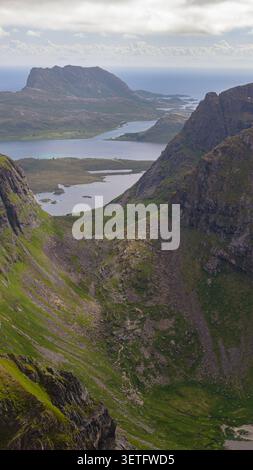 Vallée montagneuse spectaculaire avec des lacs immaculés nichés entre des sommets imposants des Lofoten, Norvège. Paysage alpin accidenté recouvert de mousse Banque D'Images