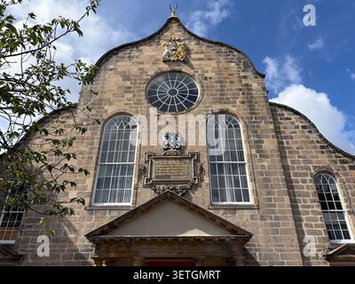 Façade extérieure de Canongate Kirk, une église historique en pierre du XVIIe siècle à Édimbourg, en Écosse, avec des fenêtres cintrées et une plaque de pierre sculptée. Banque D'Images