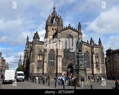 Vue extérieure de la cathédrale St Giles et de la statue de John Knox à Édimbourg, en Écosse, avec des touristes dans la rue historique. Banque D'Images