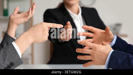 Hommes d'affaires faisant des gestes lors d'une discussion en réunion de bureau Banque D'Images
