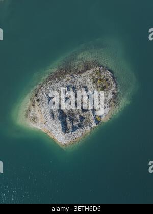 Vue aérienne du réservoir Guadalest avec une petite île rocheuse avec des ruines de pierre anciennes entourées d'eau turquoise à Alicante, commune valencienne Banque D'Images