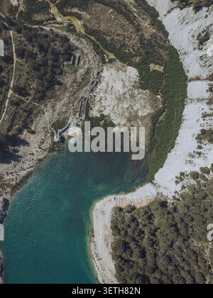 Vue aérienne du réservoir Guadalest avec son eau turquoise, ses falaises rocheuses et les forêts de pins environnantes à Alicante, Communauté valencienne, Espagne. Banque D'Images