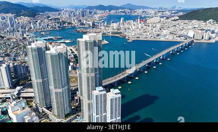Le paysage urbain de Busan présente des gratte-ciel modernes, un pont en porte-à-faux enjambant la mer et un port très fréquenté avec un trafic maritime Banque D'Images