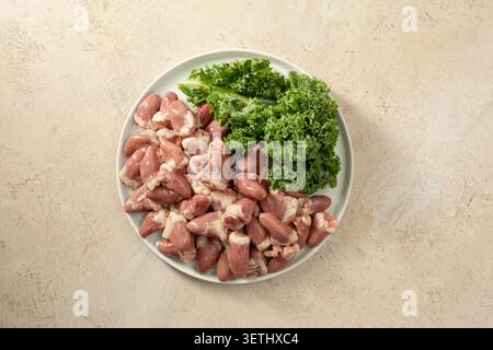 Une vue de dessus d'une assiette de cœurs de poulet crus. Banque D'Images