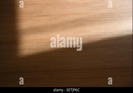 Surface en bois du bureau ou de la table avec la lumière du soleil comme texture ou fond Banque D'Images