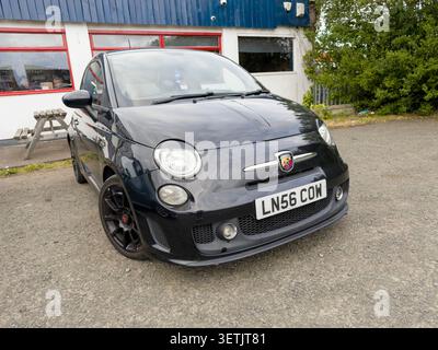 Vue de face Black Fiat Abarth 500 hatchback stationné sur gravier à l'extérieur d'un bâtiment au Royaume-Uni Banque D'Images