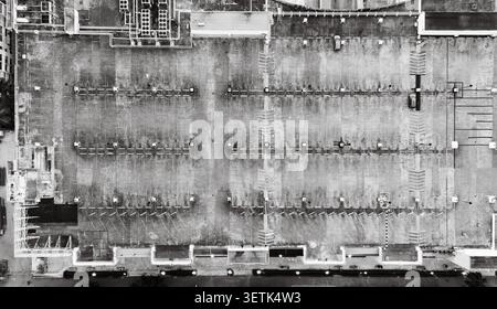 Vue aérienne d'un grand parking avec des espaces marqués, des unités de ventilation, et quelques voitures garées à Santo Domingo, République Dominicaine. Banque D'Images