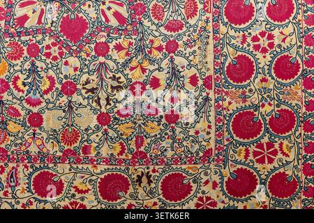 Broderie colorée complexe sur un textile traditionnel avec des motifs floraux ouzbeks cousus à la main, des vignes tourbillonnantes et des motifs ornementaux. Tachkent, Banque D'Images