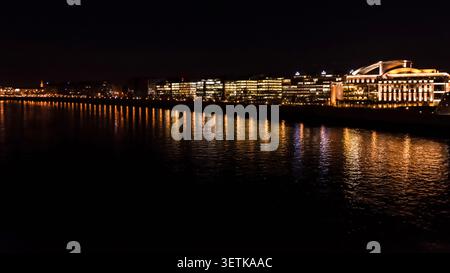 Vue nocturne des bâtiments commerciaux modernes illuminés et des bureaux le long des rives du Danube à Budapest, Hongrie. Banque D'Images