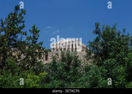 Athènes, Grèce. 21 juin 2026. L'Acropole est vue à travers des arbres de la colline d'Areopagus à Athènes, Grèce, le 21 juin 2026. L'Acropole, site classé au patrimoine mondial de l'UNESCO, est l'un des monuments archéologiques les plus visités de Grèce. Athènes attire des millions de touristes chaque année, en particulier pendant la saison estivale, malgré les périodes de chaleur extrême. (Photo de Elvis Takahashi Mantello/Middle East images/StringersHub/SIPA USA) crédit : SIPA USA/Alamy Live News Banque D'Images