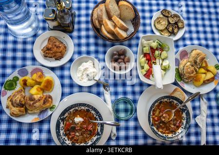 Abondant repas albanais étalé sur une table à manger extérieure avec nappe à carreaux Banque D'Images