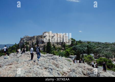 Athènes, Grèce. 21 juin 2026. Les visiteurs se tiennent sur la colline d'Aréopage surplombant l'Acropole à Athènes, en Grèce, le 21 juin 2026. L'Acropole, site classé au patrimoine mondial de l'UNESCO, est l'un des monuments archéologiques les plus visités de Grèce. Athènes attire des millions de touristes chaque année, en particulier pendant la saison estivale, malgré les périodes de chaleur extrême. (Photo de Elvis Takahashi Mantello/Middle East images/StringersHub/SIPA USA) crédit : SIPA USA/Alamy Live News Banque D'Images