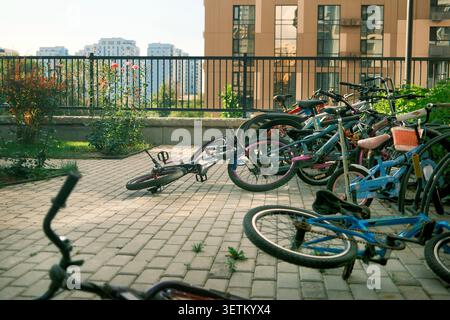 Rangée de vélos garés à l'extérieur dans un quartier résidentiel moderne. Idéal pour la vie urbaine, le transport écologique et les concepts de style de vie communautaire. Banque D'Images