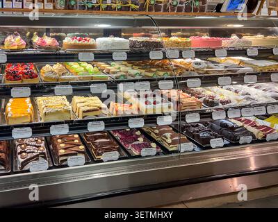 Une grande variété de desserts importés et artisanaux, y compris de nombreux gâteaux et pâtisseries dans une casserole réfrigérée dans un supermarché. Texas, États-Unis Banque D'Images