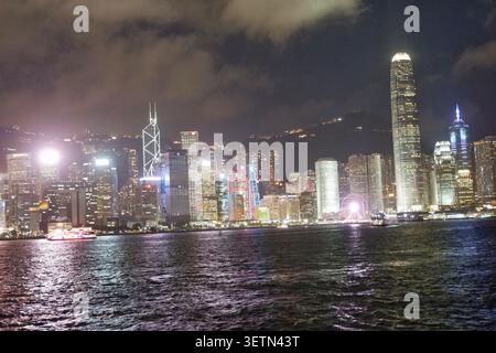 HONG KONG - 18 JUILLET 2023 : la ligne d'horizon illuminée de l'île de Hong Kong la nuit, y compris l'IFC2, la tour Bank of China et une grande roue. Banque D'Images
