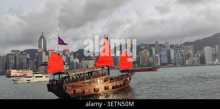 HONG KONG - 18 JUILLET 2023 : le bateau à voile rouge Aqua Luna traverse le port Victoria au crépuscule. Banque D'Images