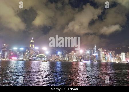 HONG KONG - 18 JUILLET 2023 : Central Plaza et le Hong Kong Convention and Exhibition Centre illuminés dans le port Victoria la nuit. Banque D'Images