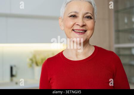 Portrait d'une femme âgée européenne élégante et confiante d'âge moyen. Vieille dame mature des années 60 souriant à la maison. Joyeux appareil photo féminin senior attrayant gros plan visage portrait photo tête. Des gens heureux Banque D'Images