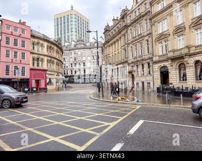 Architecture historique et scène urbaine dans le quartier Quayside de Newcastle upon Tyne, en Angleterre, avec des bâtiments en pierre et des marquages routiers. Banque D'Images